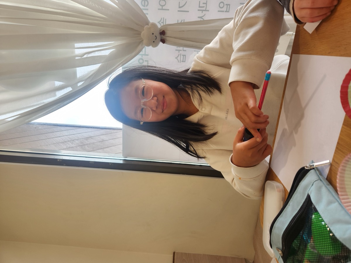 A girl smiling brightly at her desk