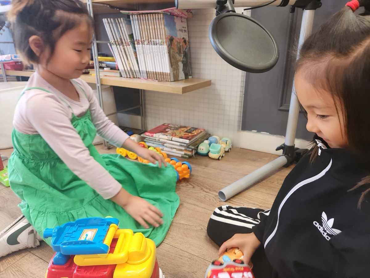Two children playing with toy cars