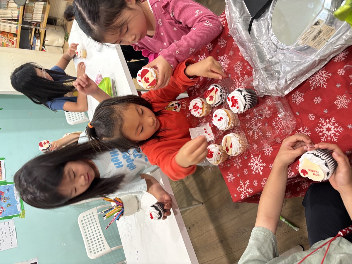 Children decorating cupcakes together at the table