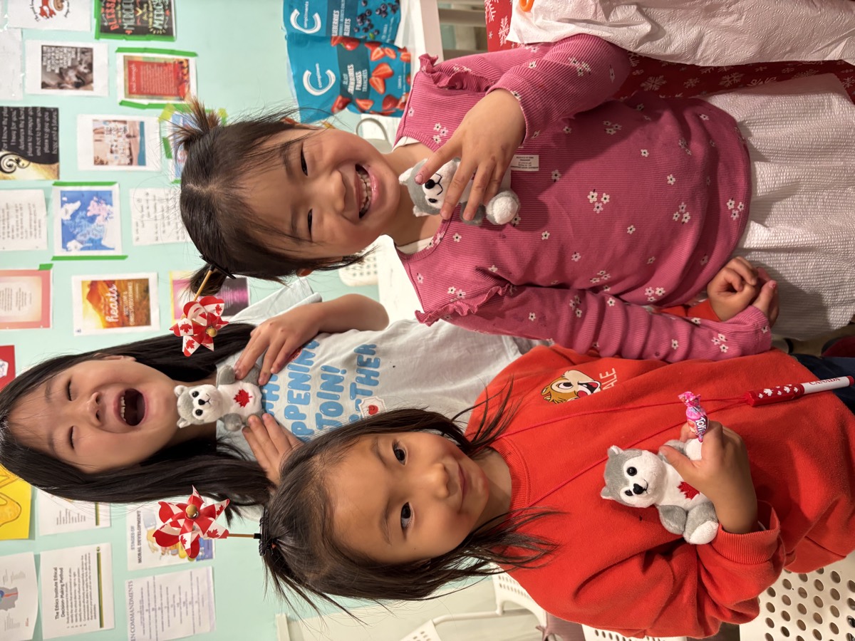 Three girls laughing together while holding husky plushies