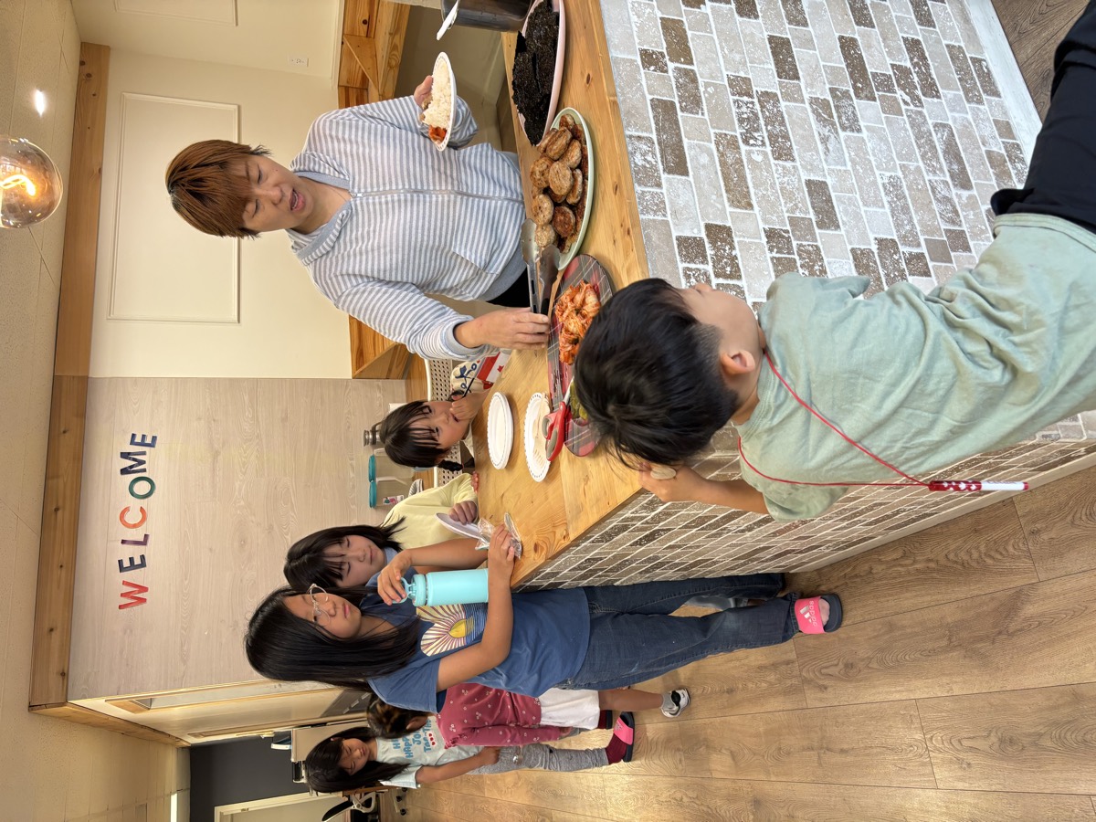 A teacher serving lunch to children at the counter