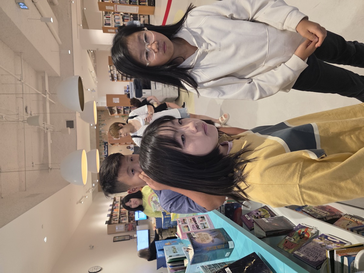 Girls browsing the library bookshelves