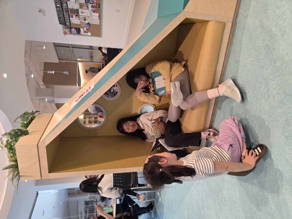 Children reading together in a triangular library reading nook