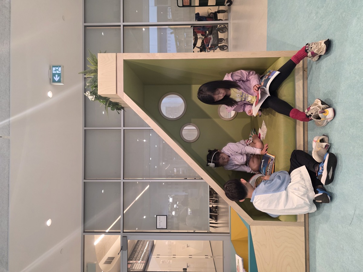 Children reading in a green library reading nook