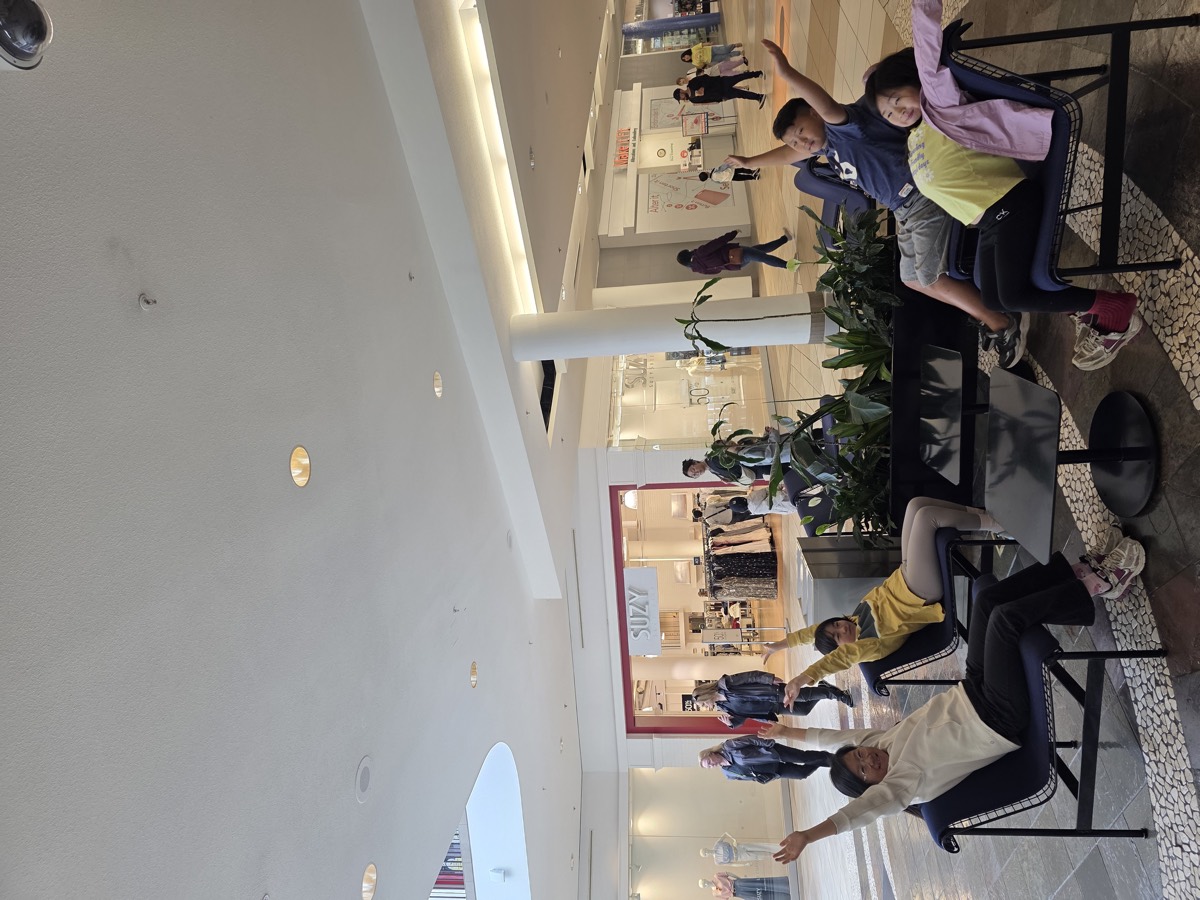 Children relaxing playfully on lounge chairs in the mall