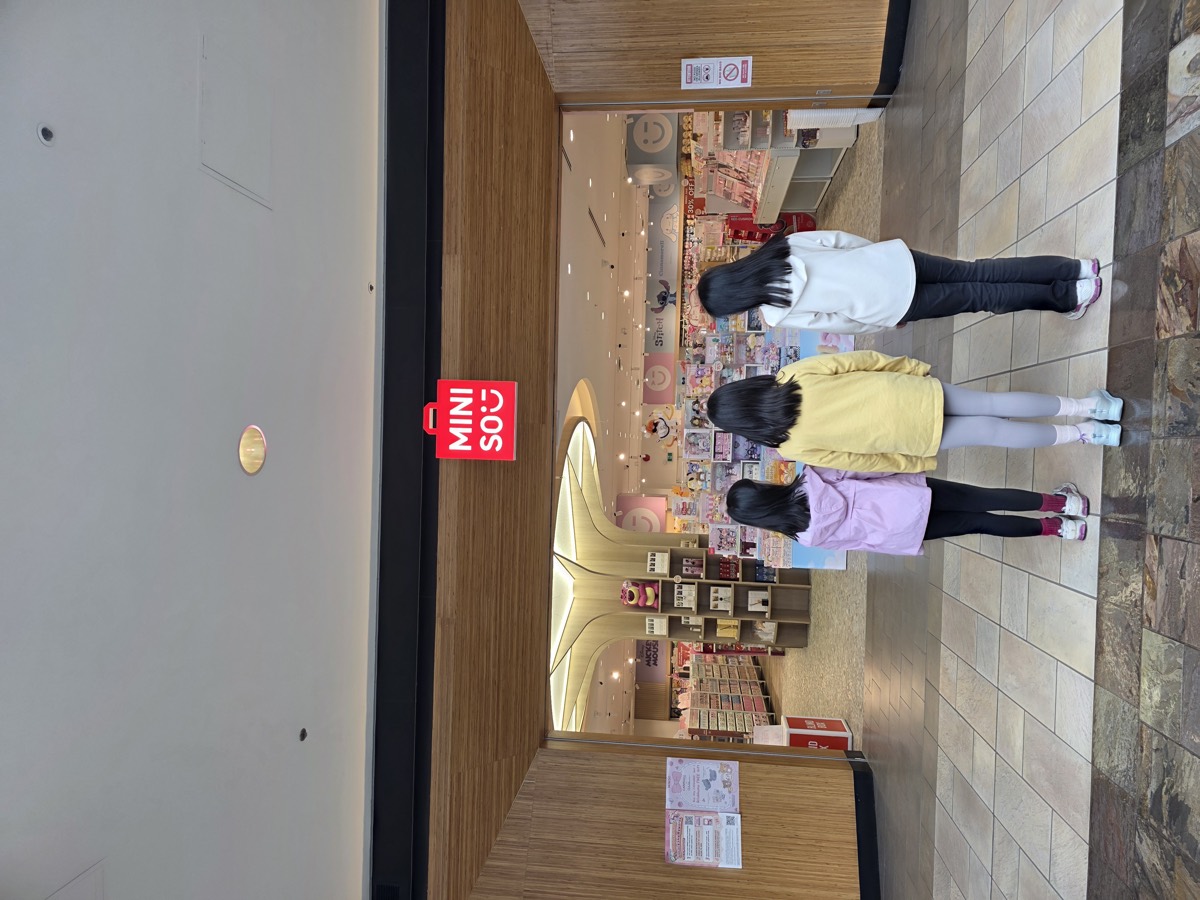 Three girls looking into a shop window