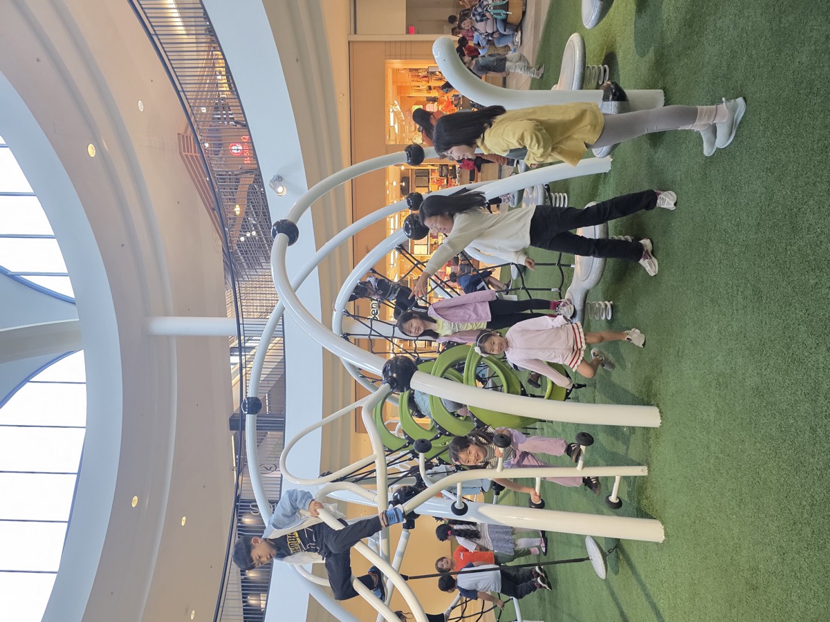 Children playing on a large white indoor climbing structure