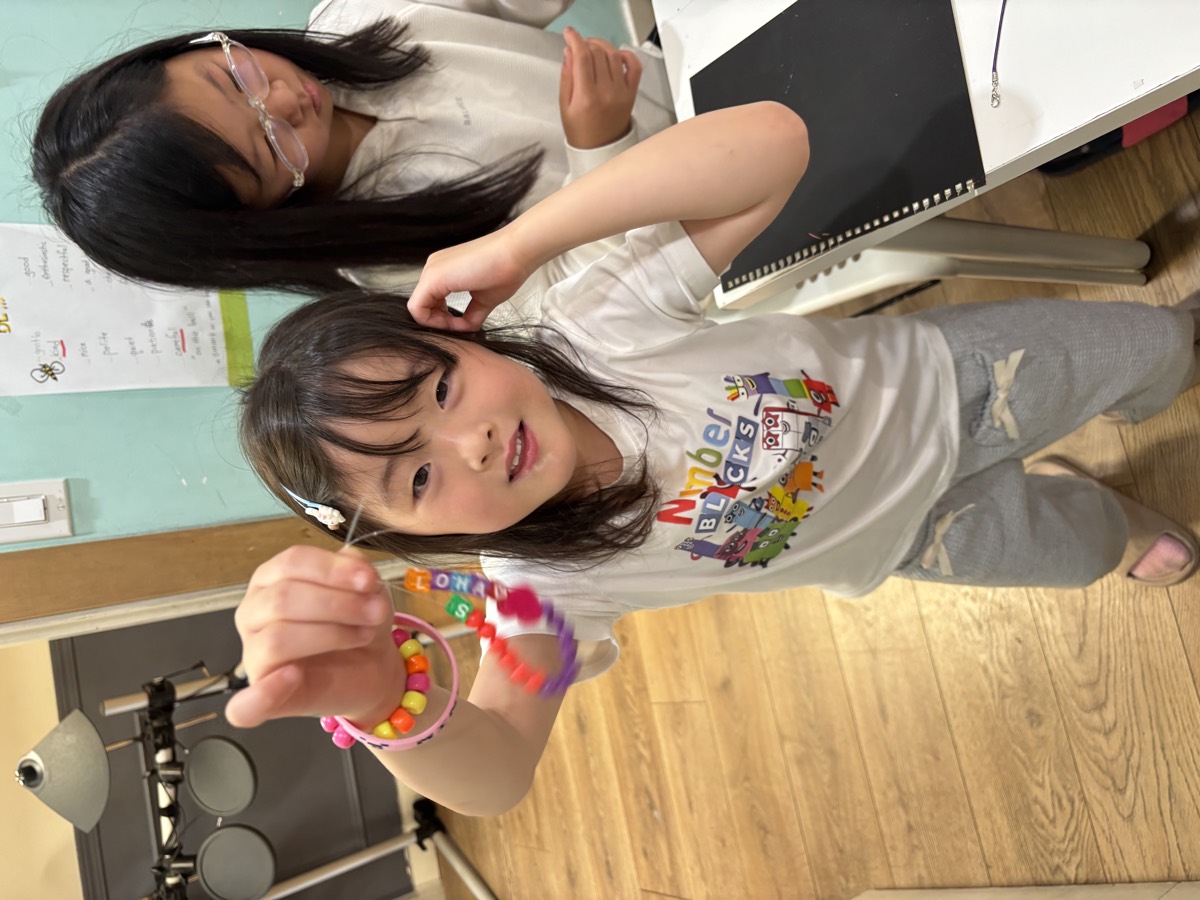 A girl showing off her colorful beaded bracelet