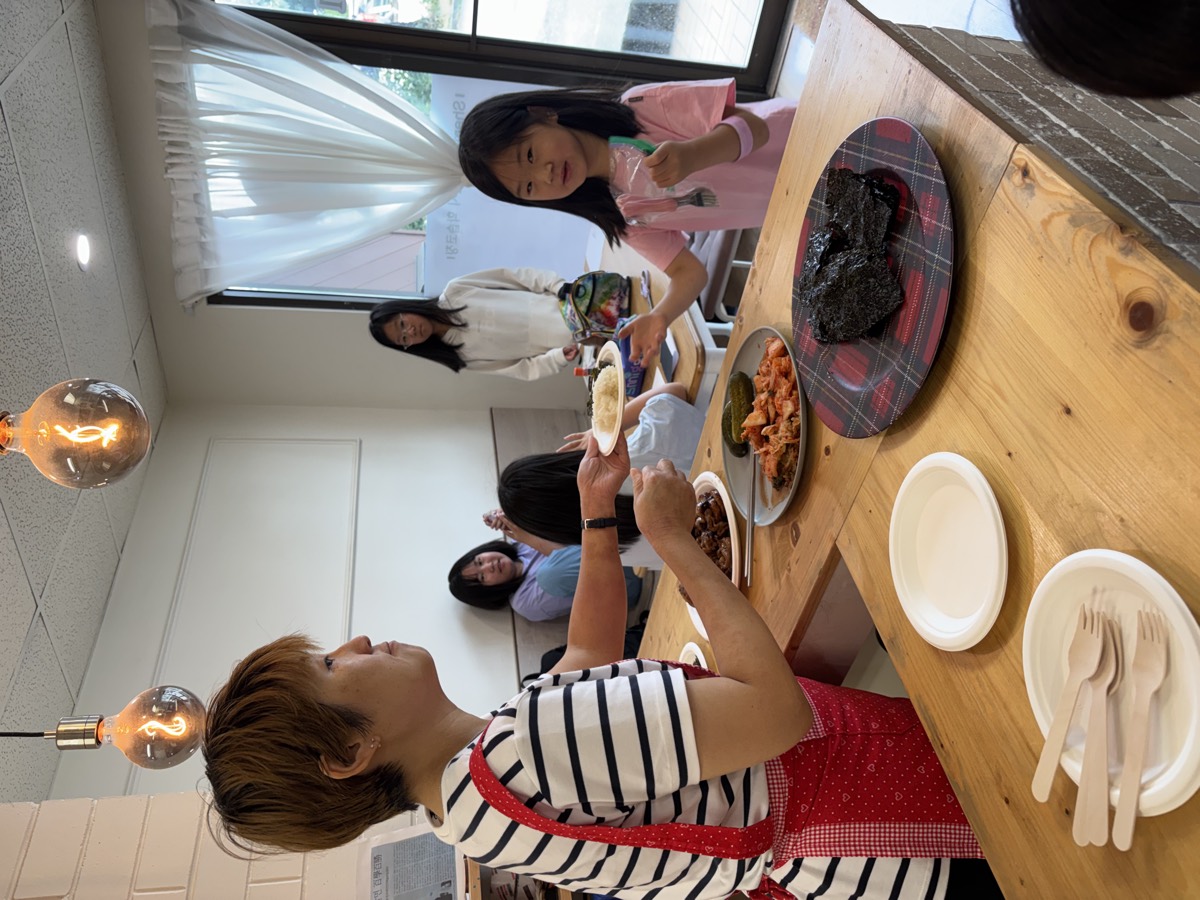 A teacher serving lunch to a child at the counter