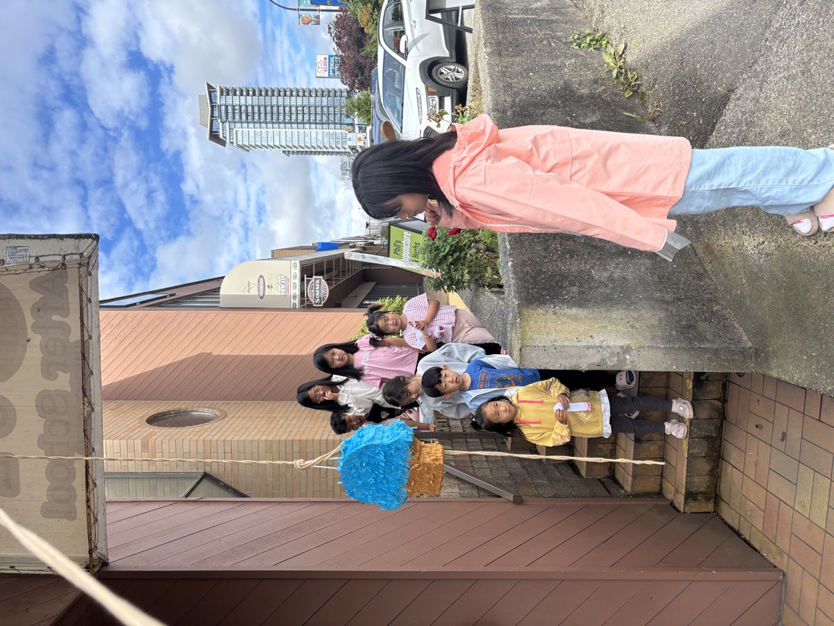 Children lined up on the steps waiting for their turn at the piñata