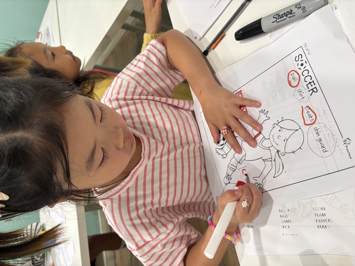 A girl coloring a soccer worksheet