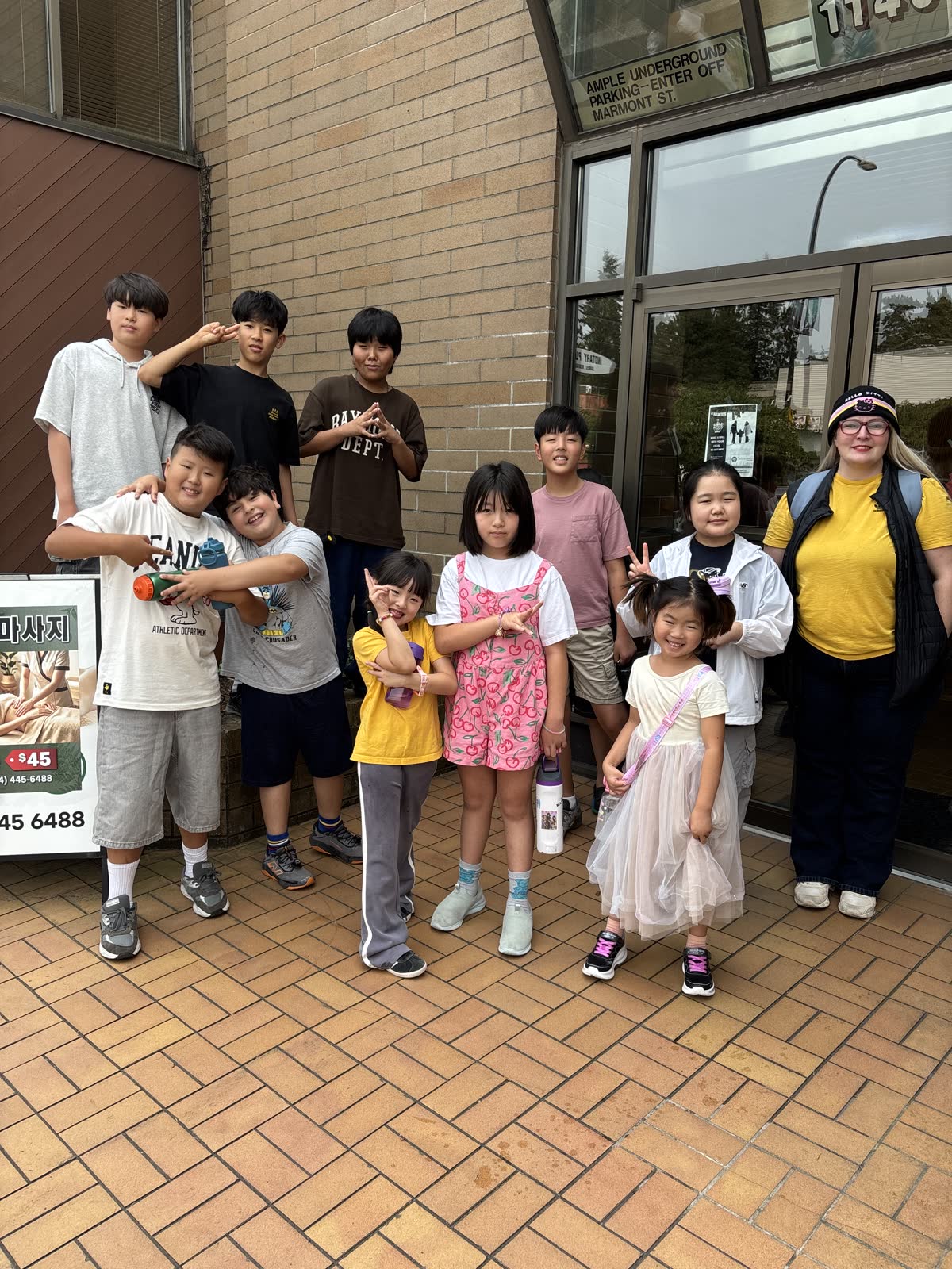 Summer campers and their teacher gathered together outside JC After School