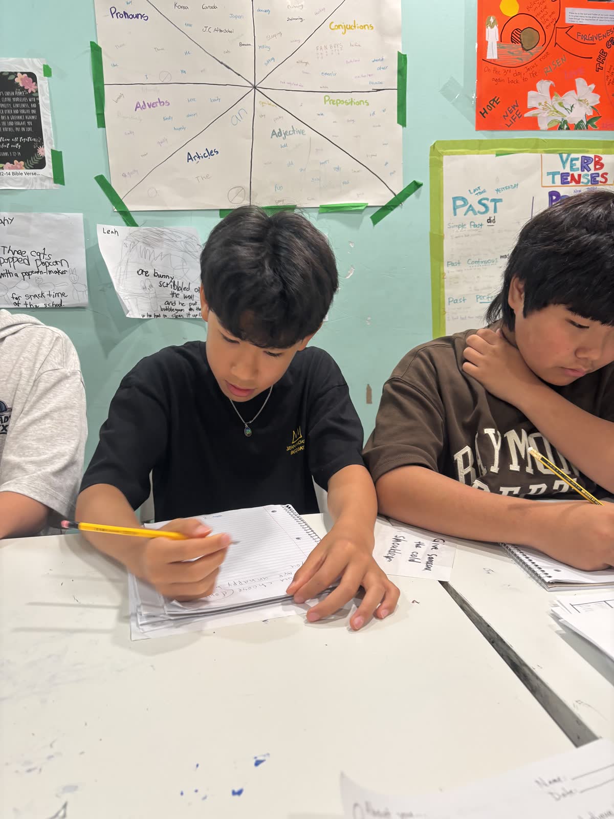 Two students concentrating on their handwritten adventure books