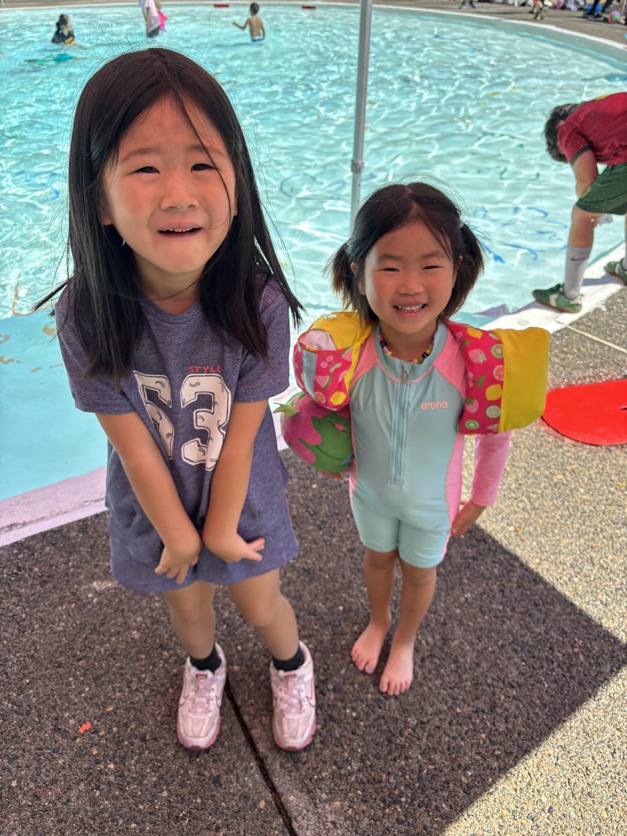Two young students standing at the poolside smiling