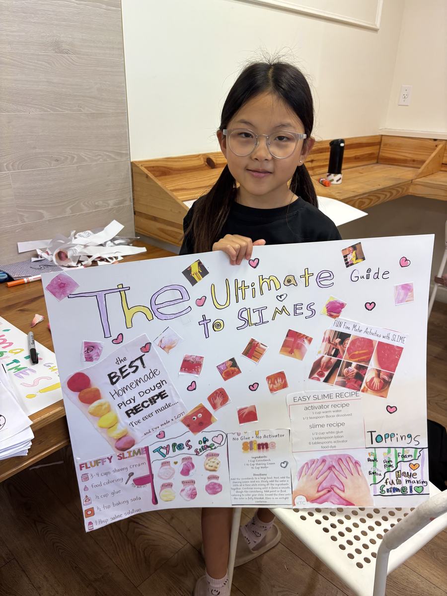 A student holding up her poster titled The Ultimate Guide to Slimes