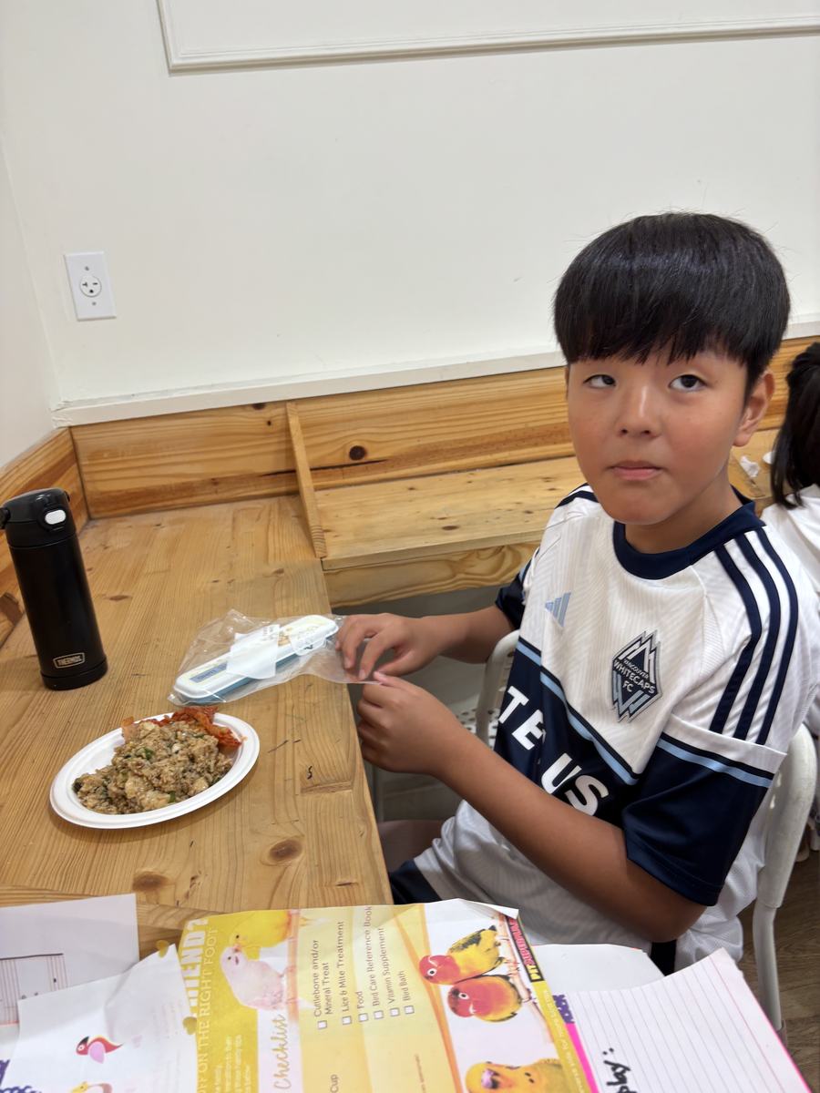 A student sitting with his plate beside an open workbook