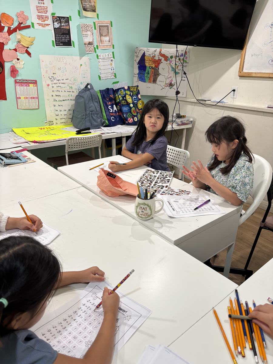 Students concentrating on their worksheets with pencils spread across the table