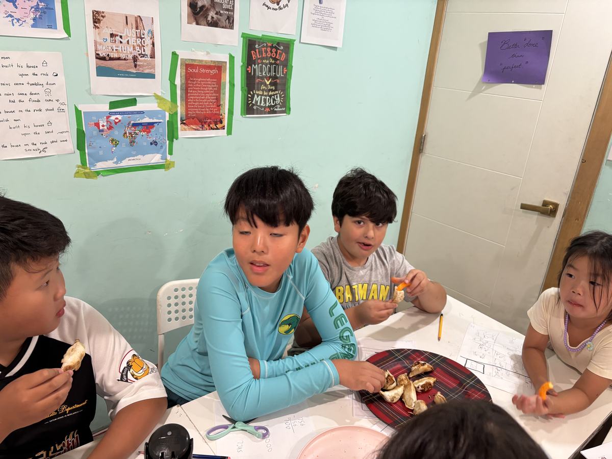 Students gathered round the table sharing a plate of pan-fried dumplings