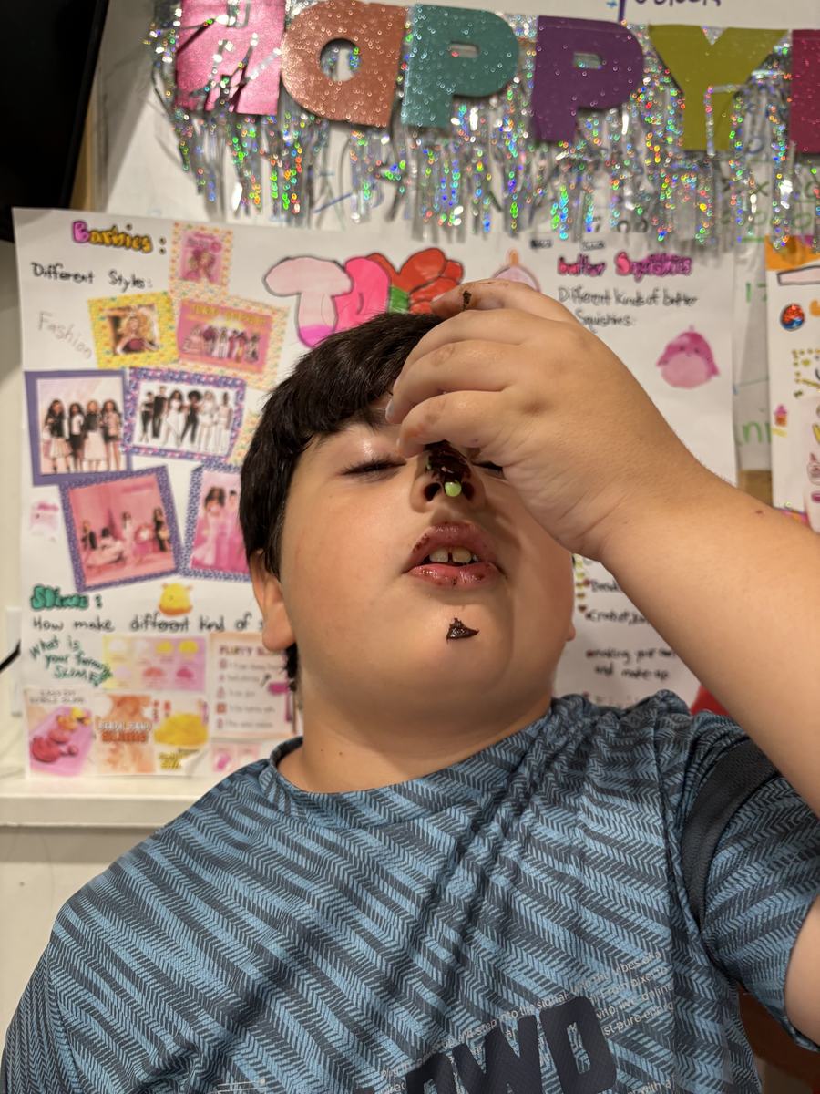 A student taking a large bite of his cupcake