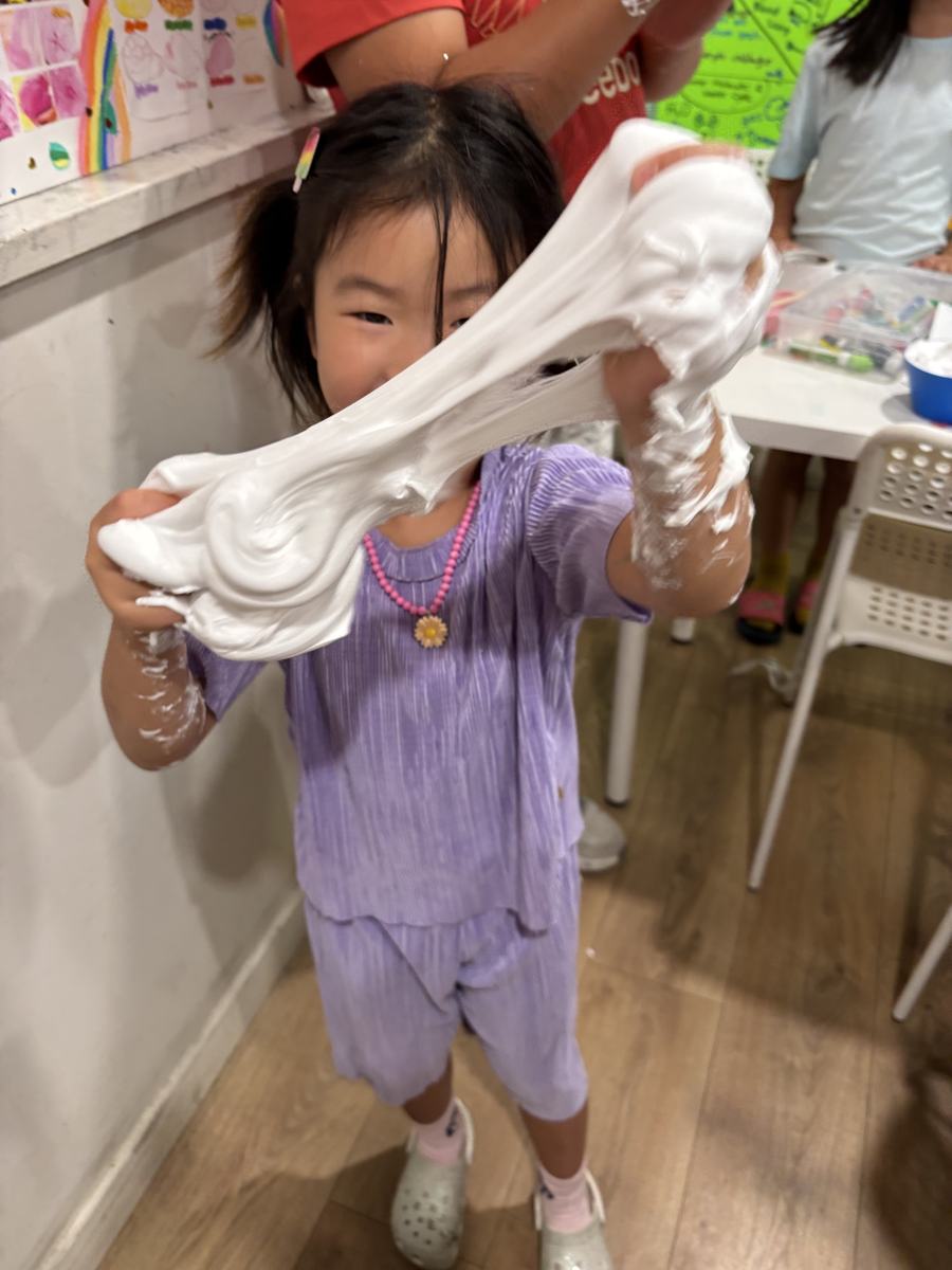 A student stretching the finished white slime between both hands