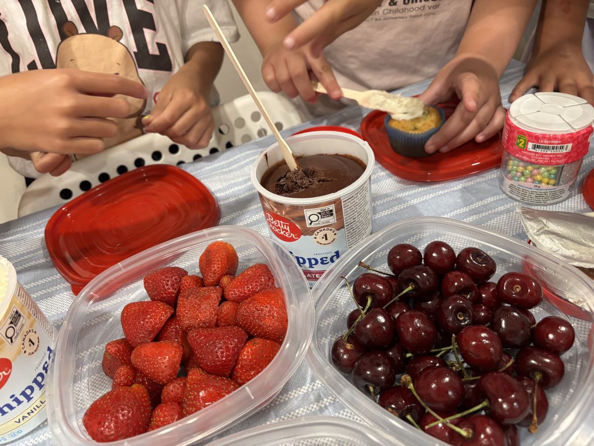 Trays of fresh strawberries and dark cherries laid out for decorating