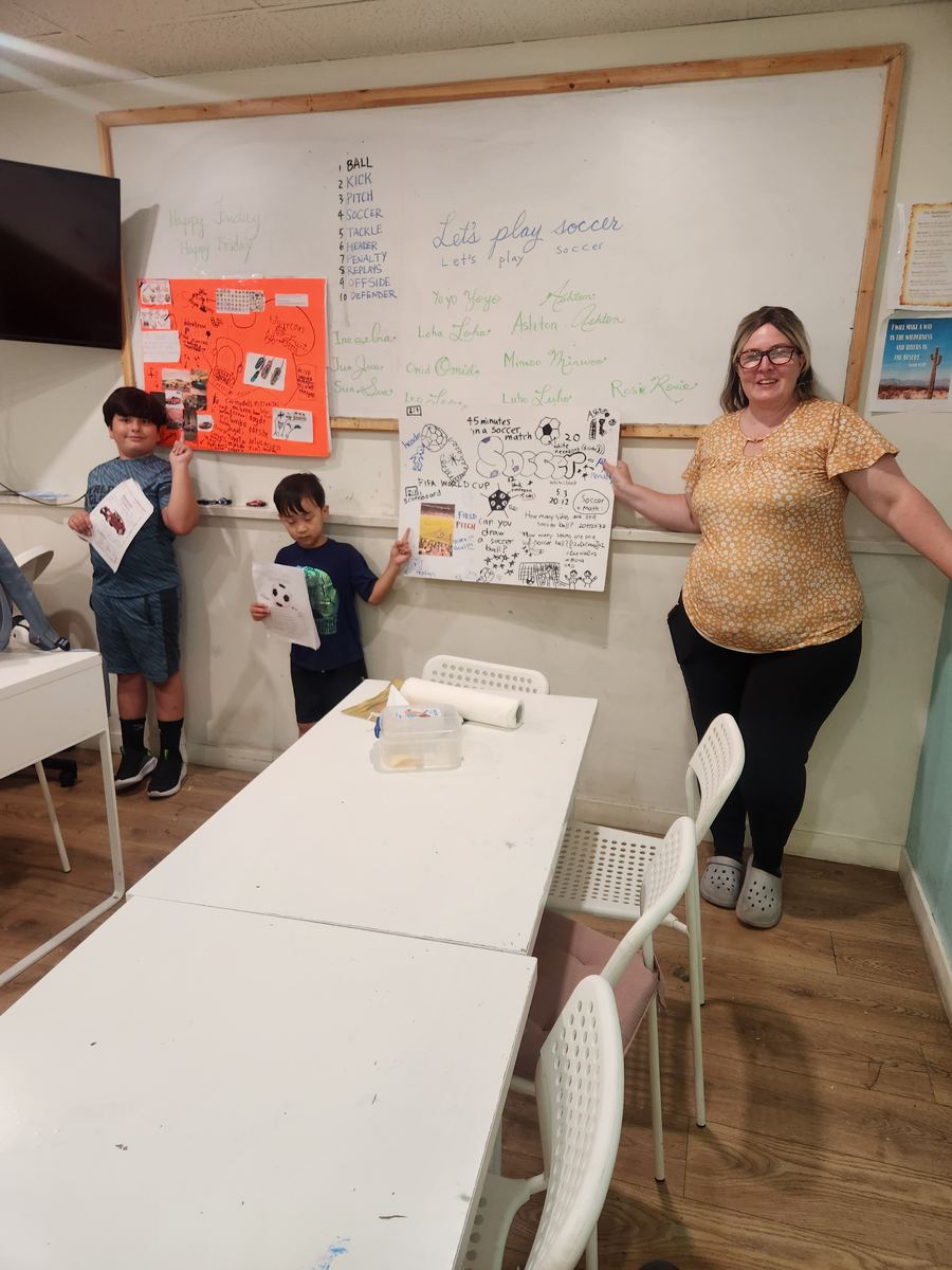Two students presenting their posters together at the front of the classroom