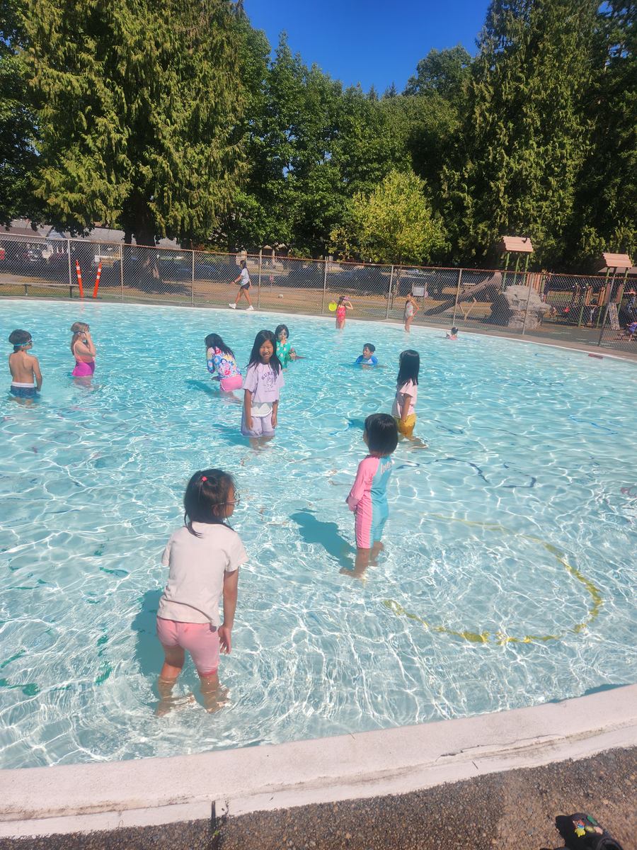 Students wading across the shallow end together