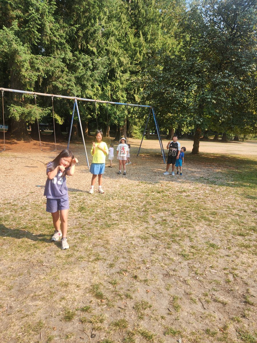 Students taking turns on the swings in the afternoon sun