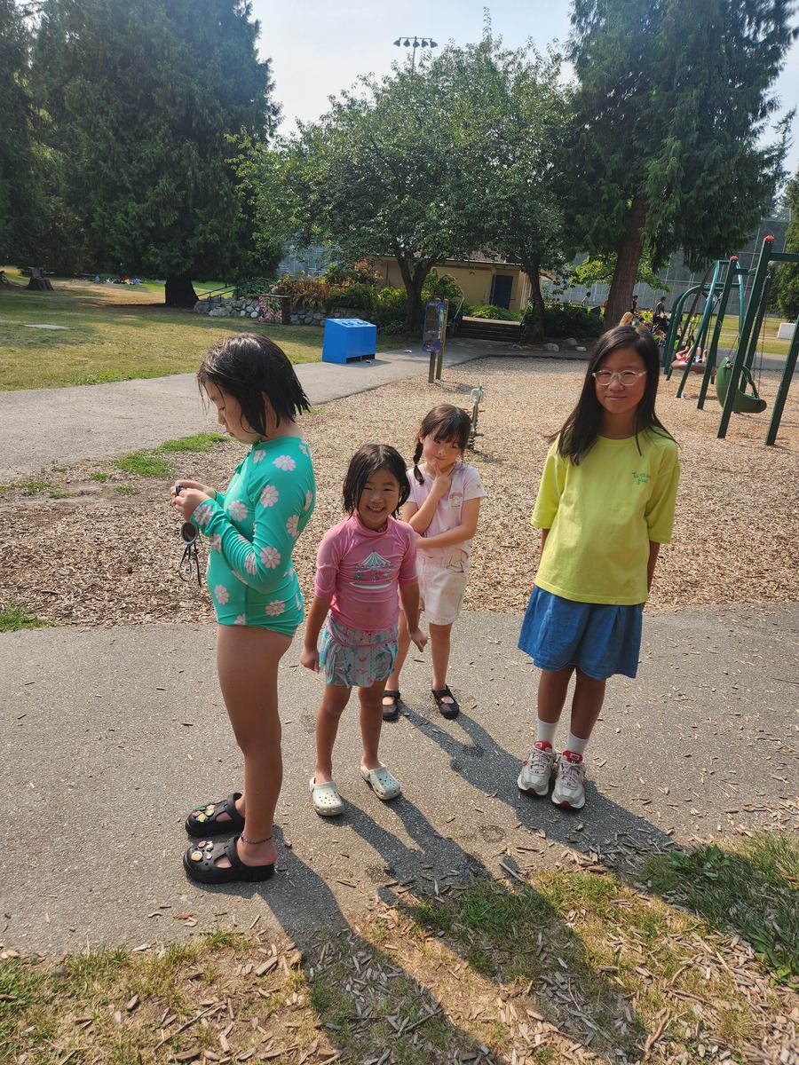 Four students walking together along the park path