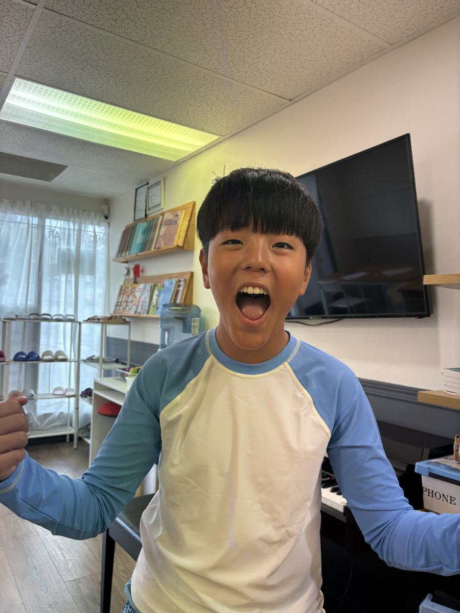 A student throwing his arms wide and cheering in the classroom