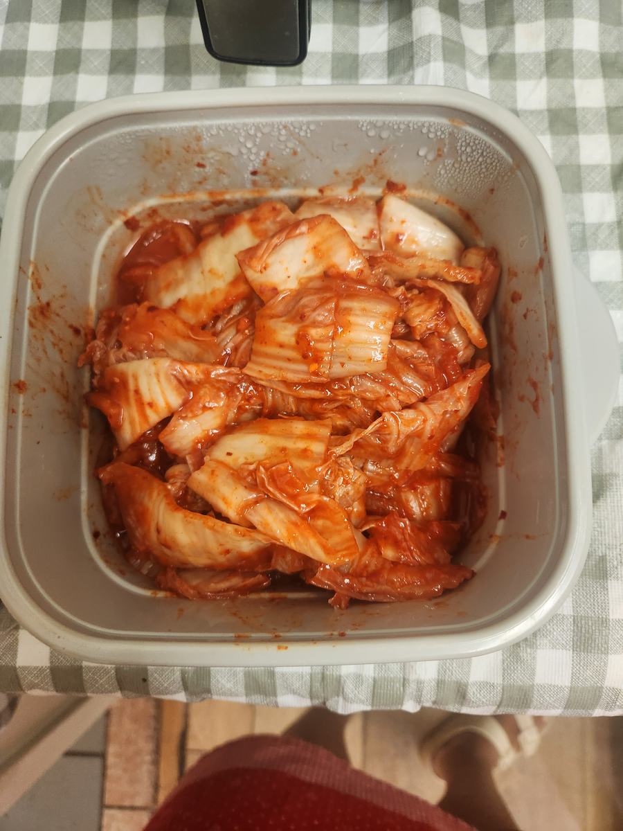 A container of freshly cut kimchi on the lunch table