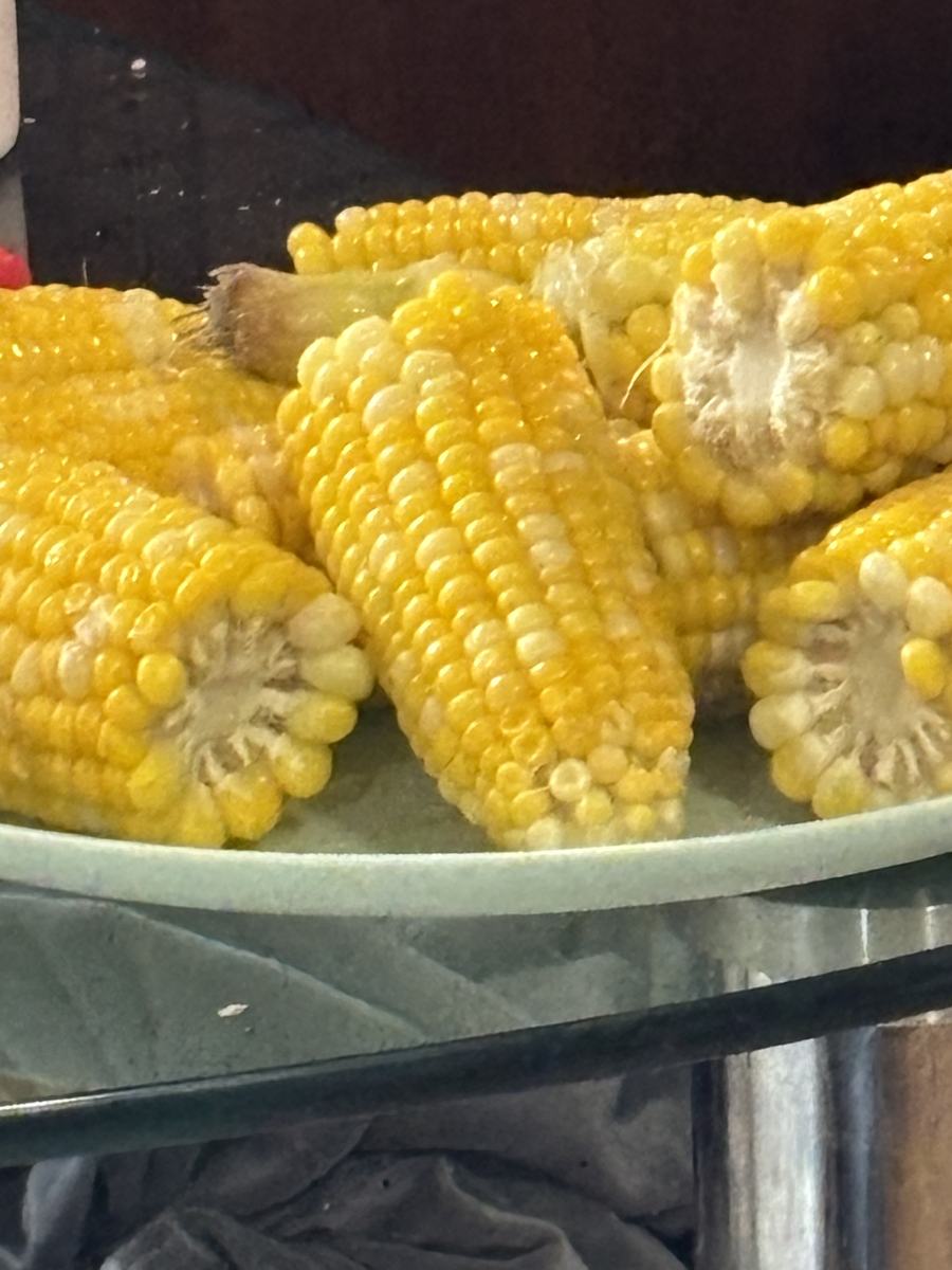 A glass plate piled with boiled corn on the cob