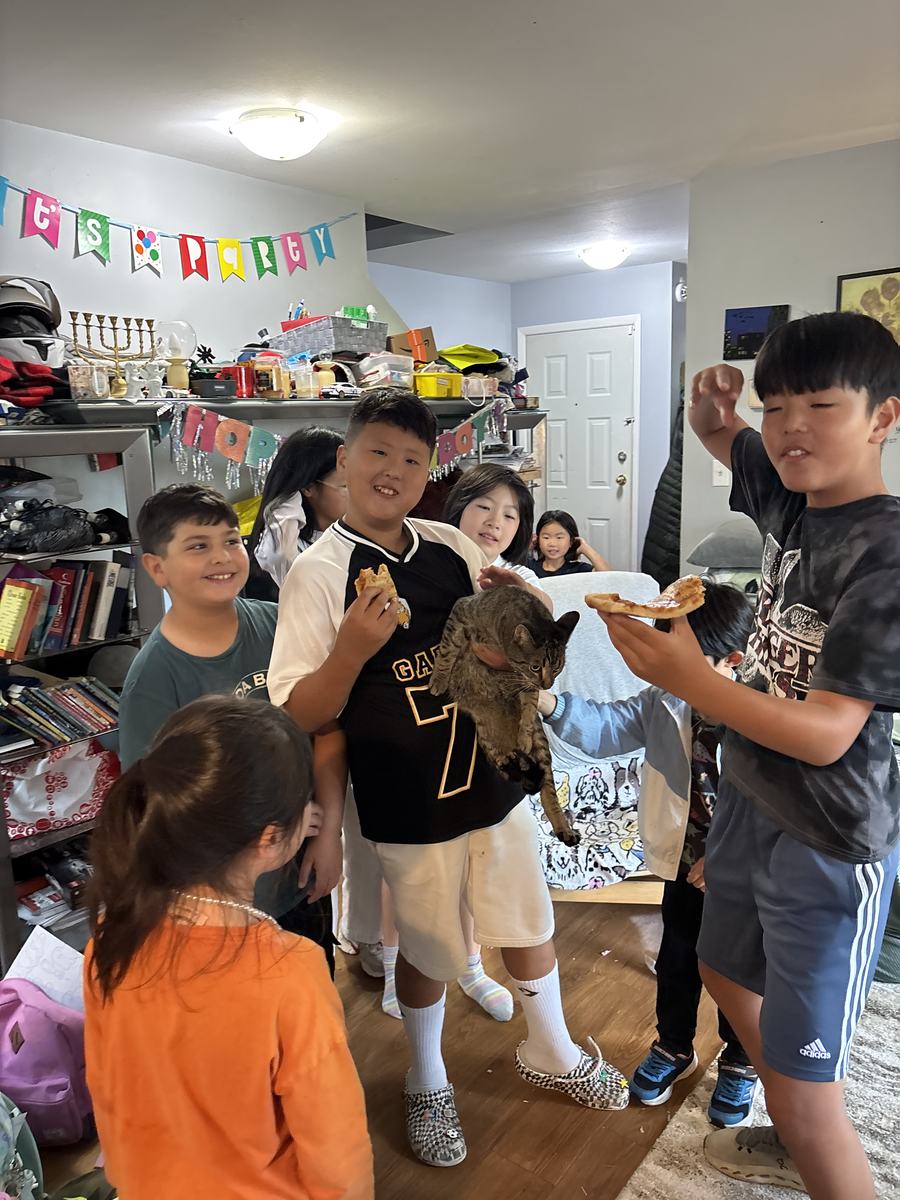 Students standing around the living room eating together and laughing