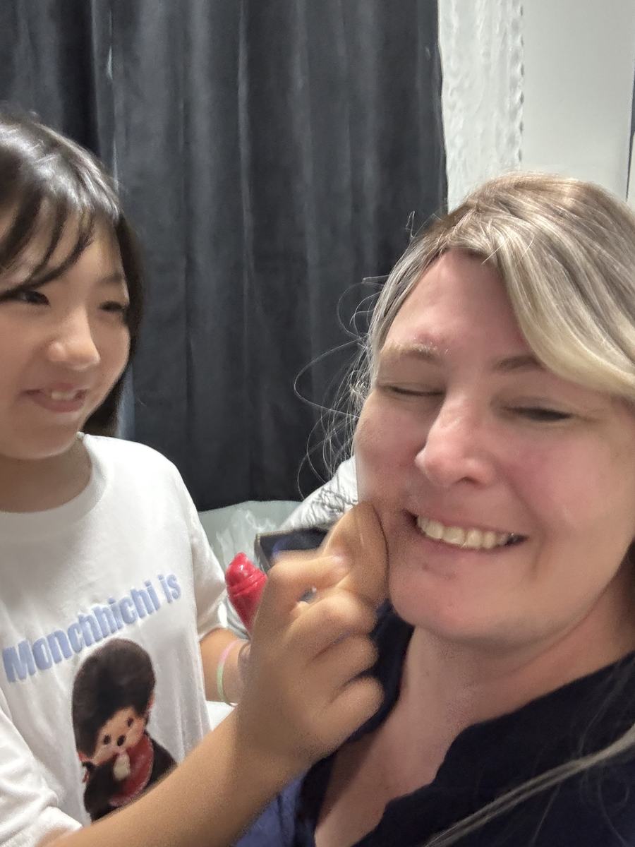 A student laughing and leaning in close to Teacher Diane, both smiling with their eyes closed