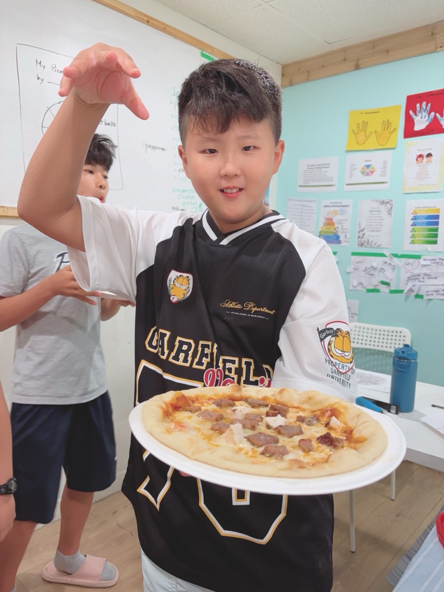 A student holding out his pizza with a theatrical flourish