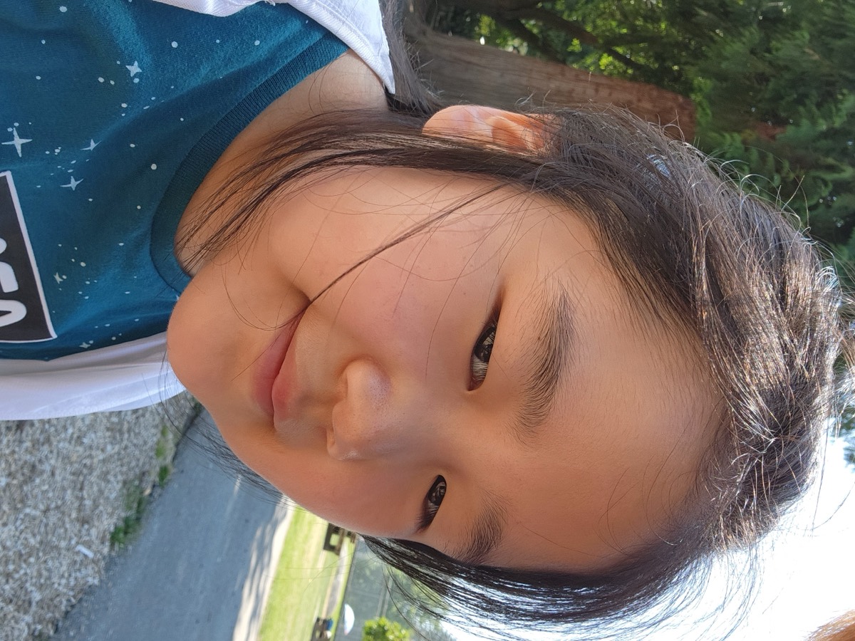 A camper smiling at the camera outdoors after a busy morning