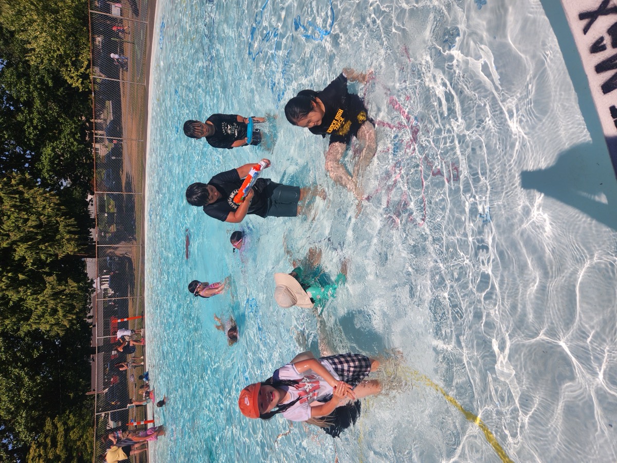 Campers playing together in the shallow end of an outdoor pool