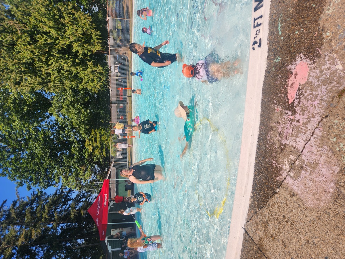 Children floating and playing in the sunny outdoor pool