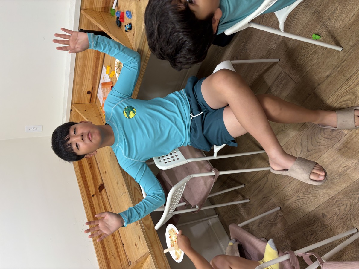 A student throwing both hands up at the table during the math game