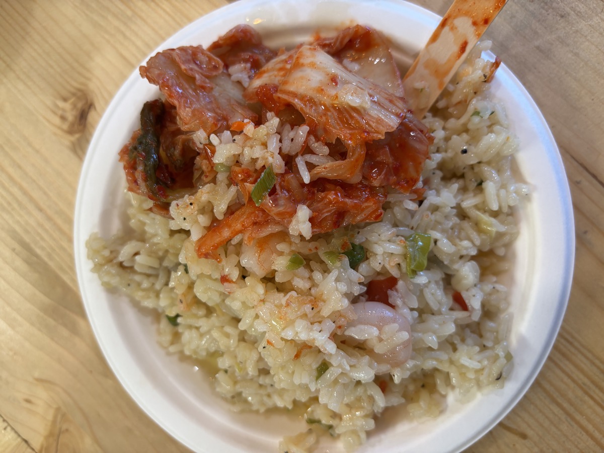 A plate of fried rice topped with kimchi
