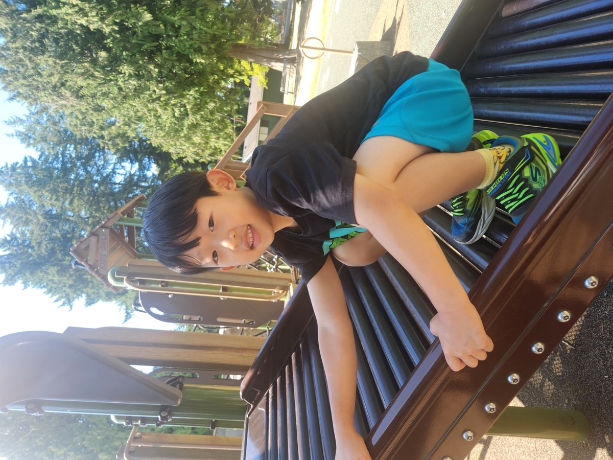 A student climbing on the playground rollers in the sunshine