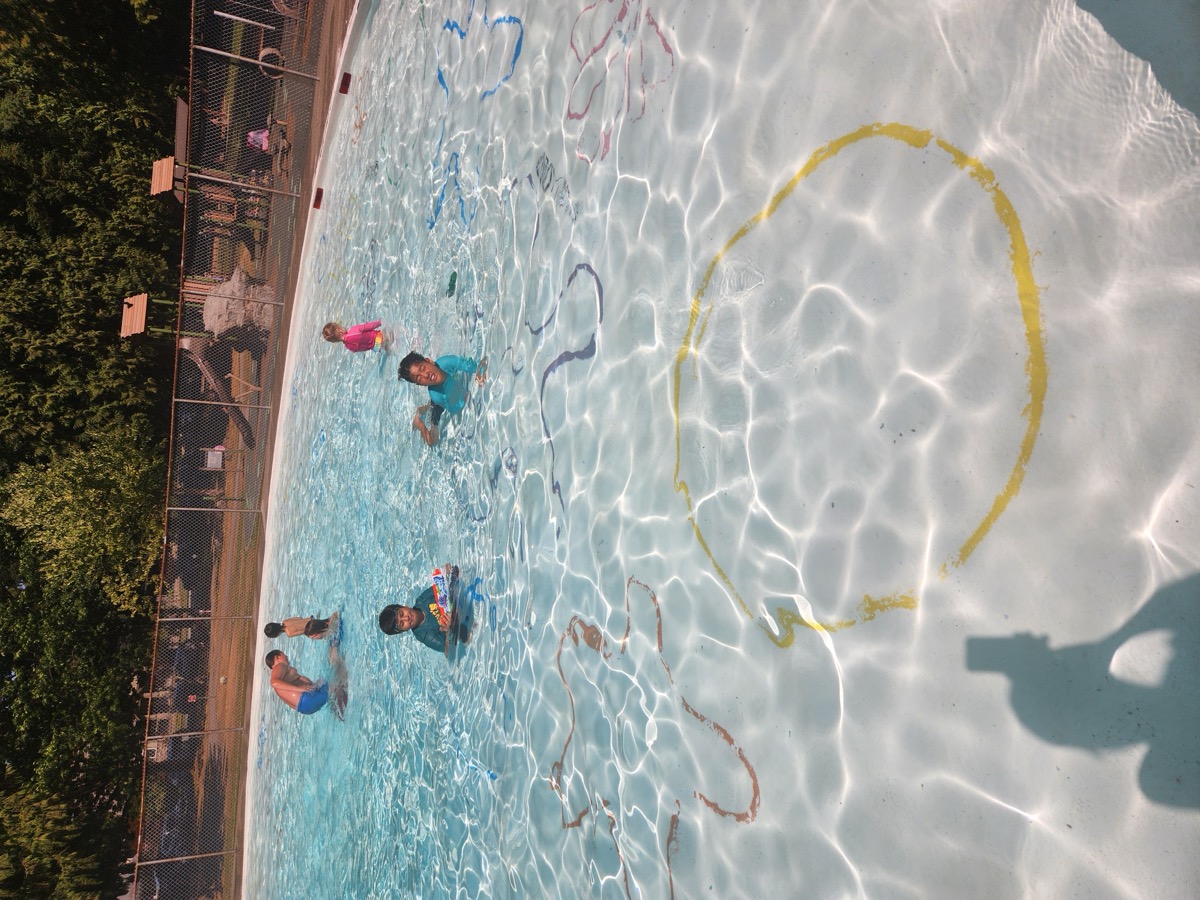 Children playing in a sunny outdoor pool