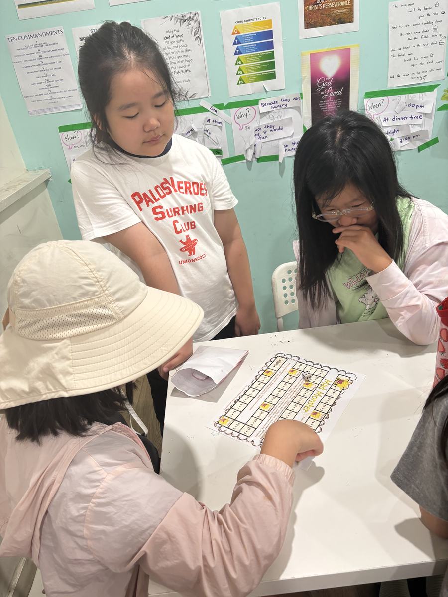 Students working through equations on their board game together