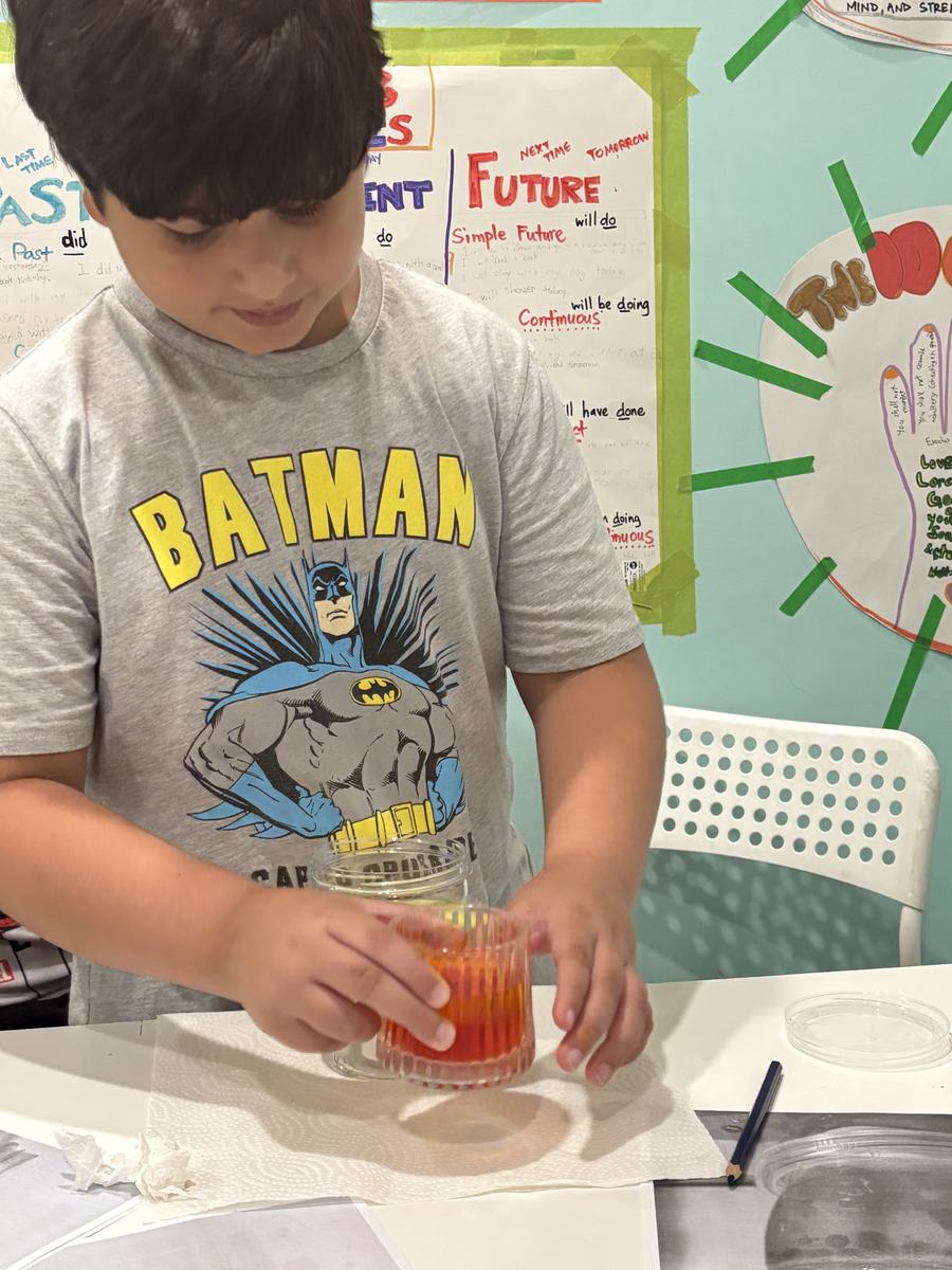 A student watching the bubbles rise in his red lava lamp jar