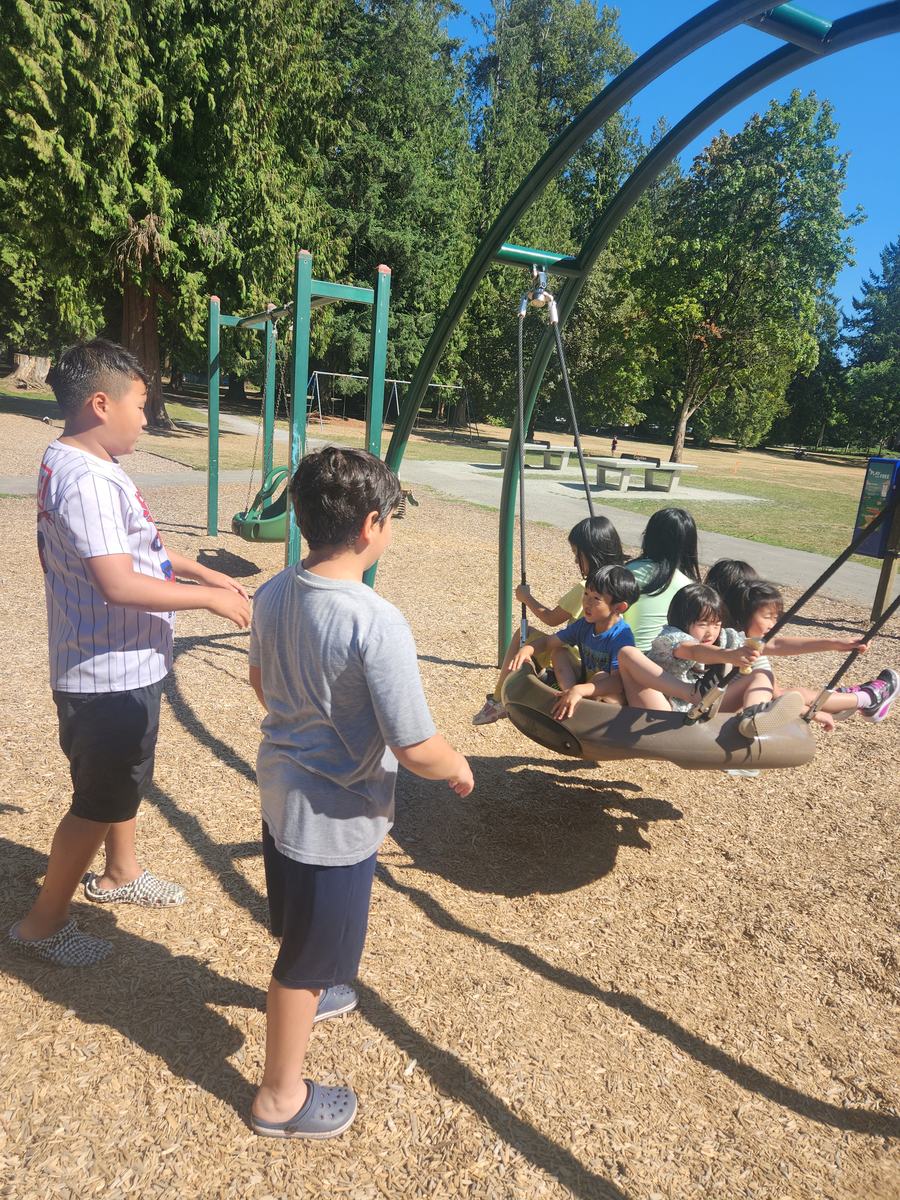 Children playing on the swings at the park playground