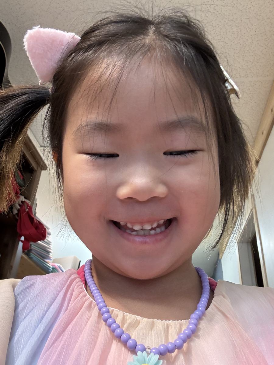 A young student beaming at the camera