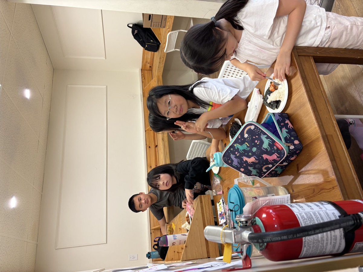 Children enjoying lunch together at a wooden table