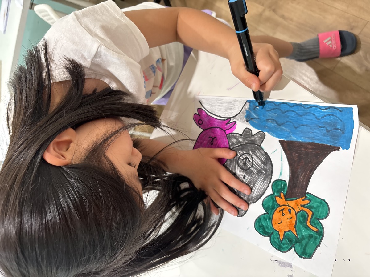 A girl coloring the illustrations for her story