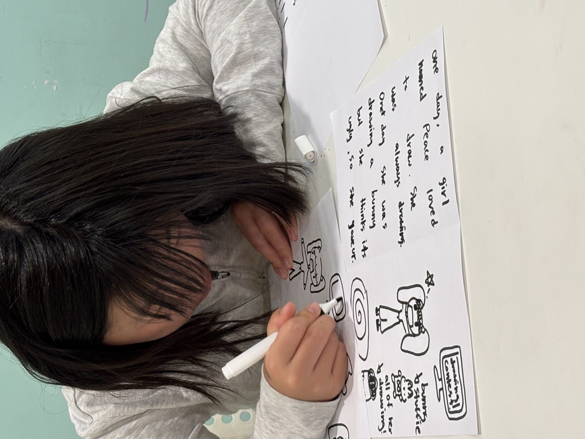 A student sketching storyboard panels for her book