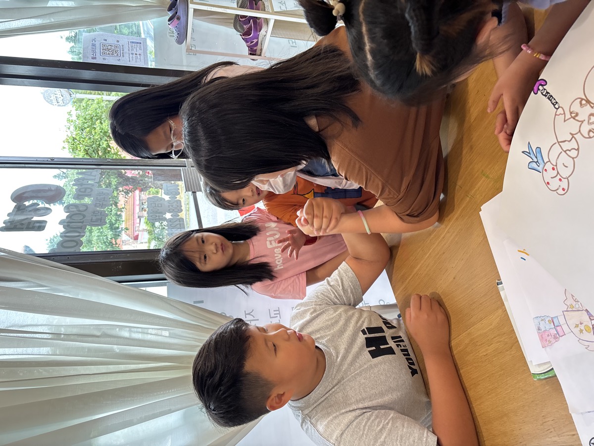 Two kids locked in an arm-wrestling match while friends watch